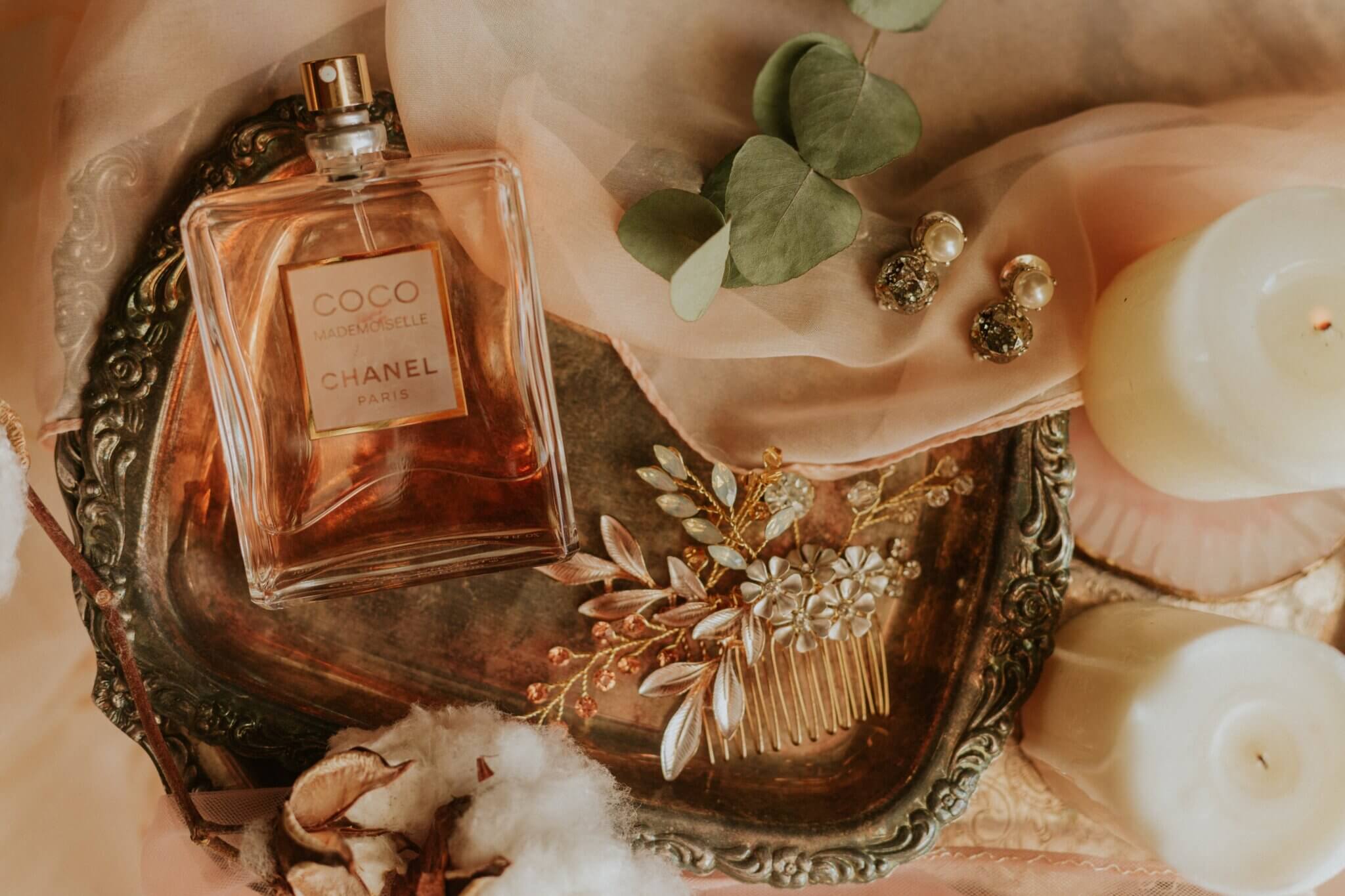 Linker Fulfillment Network for Perfumes. Picture of a bottle of perfume surrounded by delicate details and jewellery. 